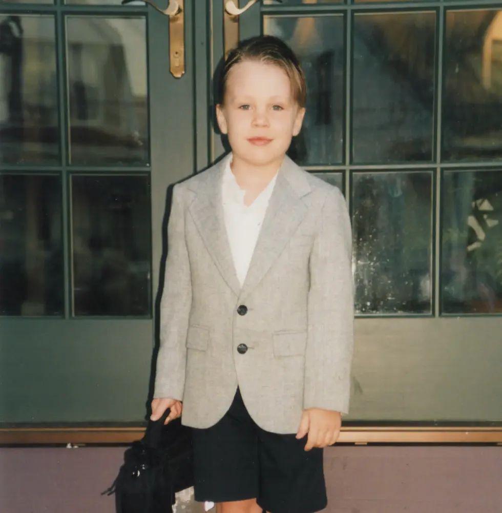 Ramsey Deal as a kindergartner in a blazer, holding a briefcase