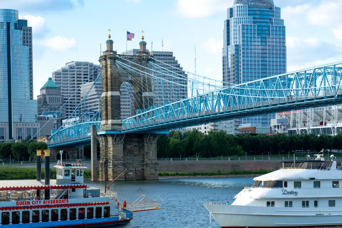 Queen City Riverboats and Destiny Yacht Charters on the Ohio River beneath the Cincinnati skyline